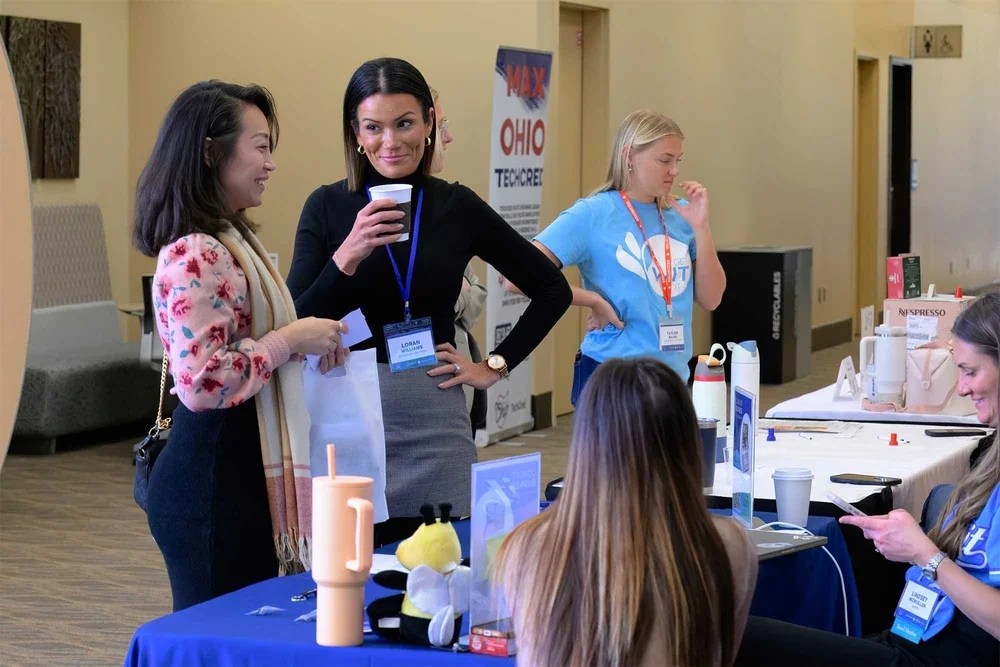Corporate event photography by Deborah Heinlen Photography, Cincinnati — women at a conference registration or check-in table at a business event