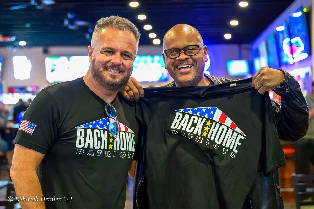 Corporate event photography by Deborah Heinlen Photography, Cincinnati — Blessid Union of Souls lead singer receiving a Back Home Patriots shirt at a corporate event
