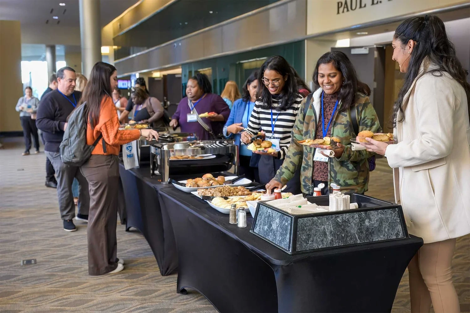 Corporate event photography by Deborah Heinlen Photography, Cincinnati — group of attendees at a vendor exhibition table at a business conference