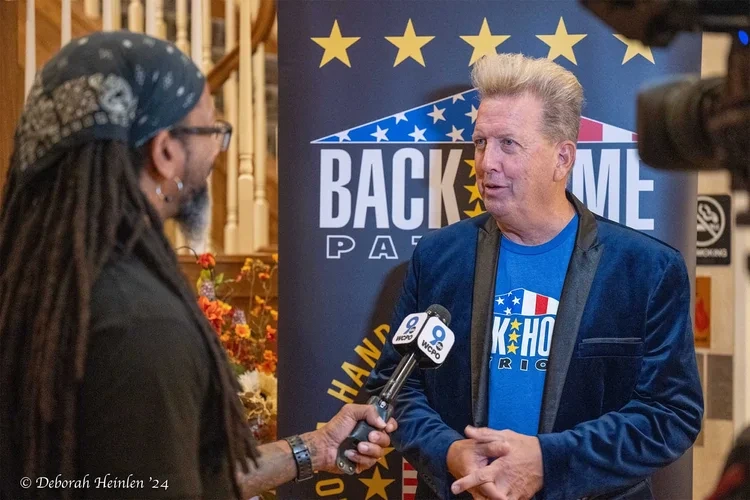 Corporate event photography by Deborah Heinlen Photography, Cincinnati — speaker at a podium with Back Home Patriots banner at a corporate event