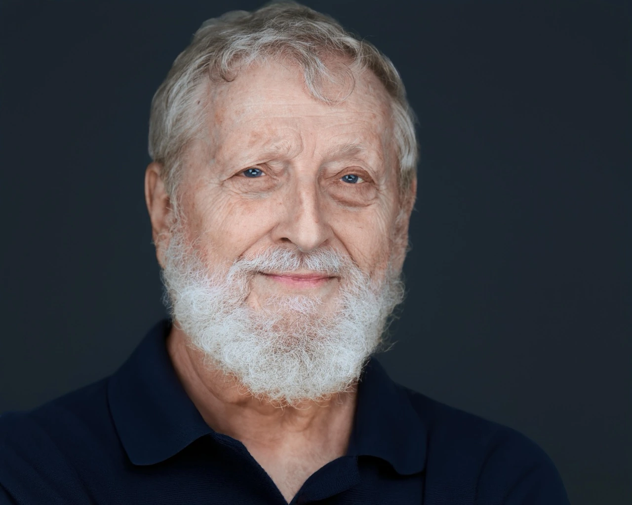 Professional male headshot by Deborah Heinlen Photography, Cincinnati — distinguished man with white beard in dark shirt against dark studio background
